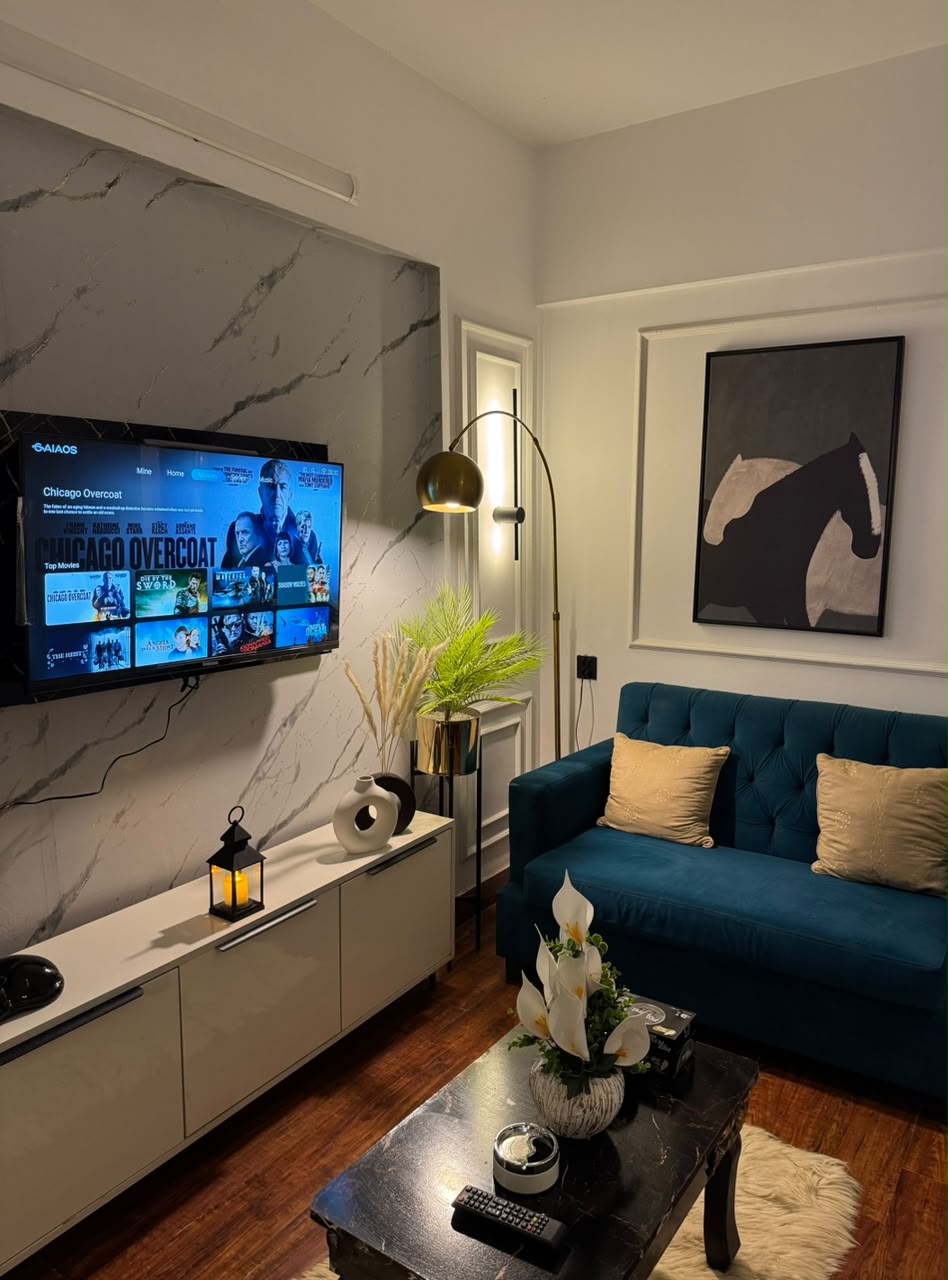 Curated Evershine living room with a deep blue sofa and entertainment wall